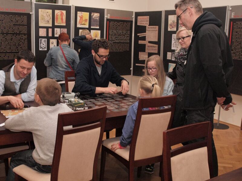 Rozgrywki w gry planszowe. W tle wystawa „Obraz wroga w propagandzie PRL